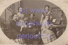 Aan de piano staande Antonia Etta Hartevelt (1854-1929). Verder van links naar rechts 1. Gouvernante, 2. met knot wol Wilhelmina Frederika Hartevelt (1857-1891), 3. Antonia Etta Modderman (1822-1884), 4. aan de piano zittend Hermanna Johanna Alida Antonia Hartevelt (1859-1942).
